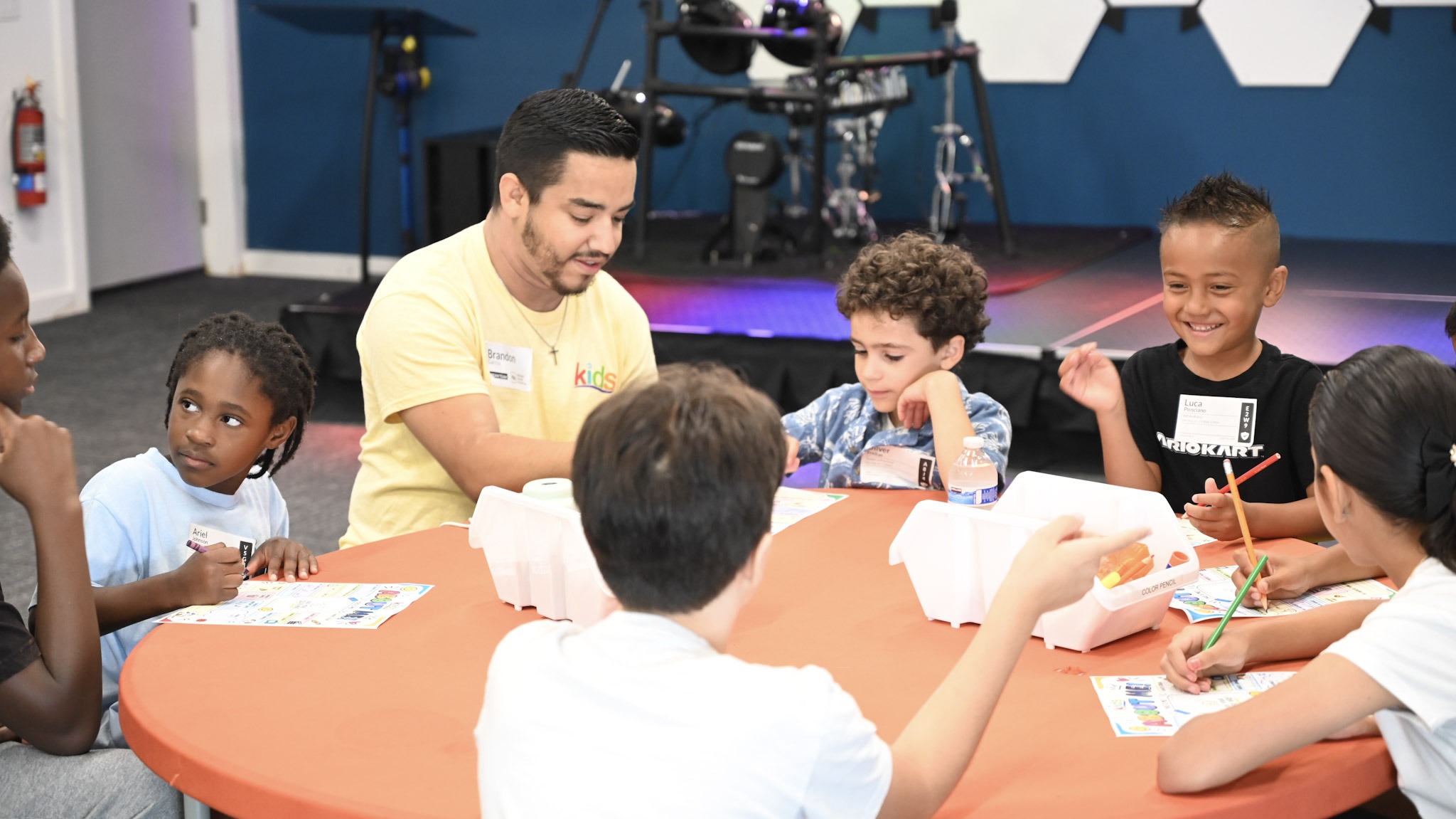 Niños participan en una actividad con un líder de Broad River Kids