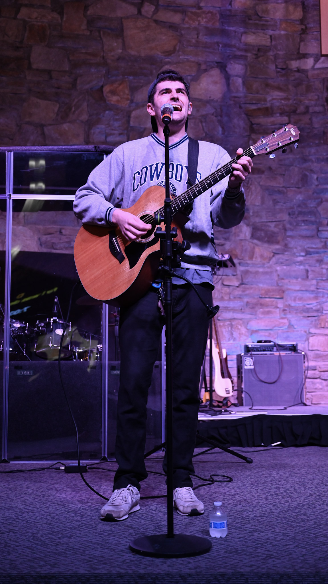 A musician singing and playing acoustic guitar during worship