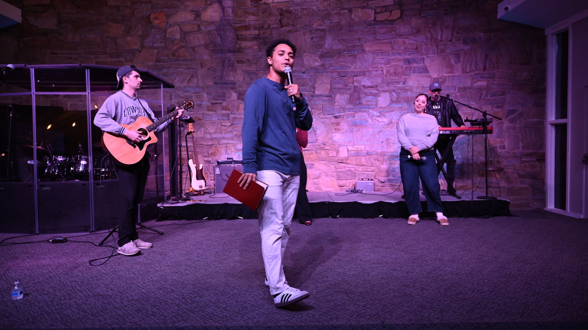 A speaker and worship team at a Broad River Young Adult service