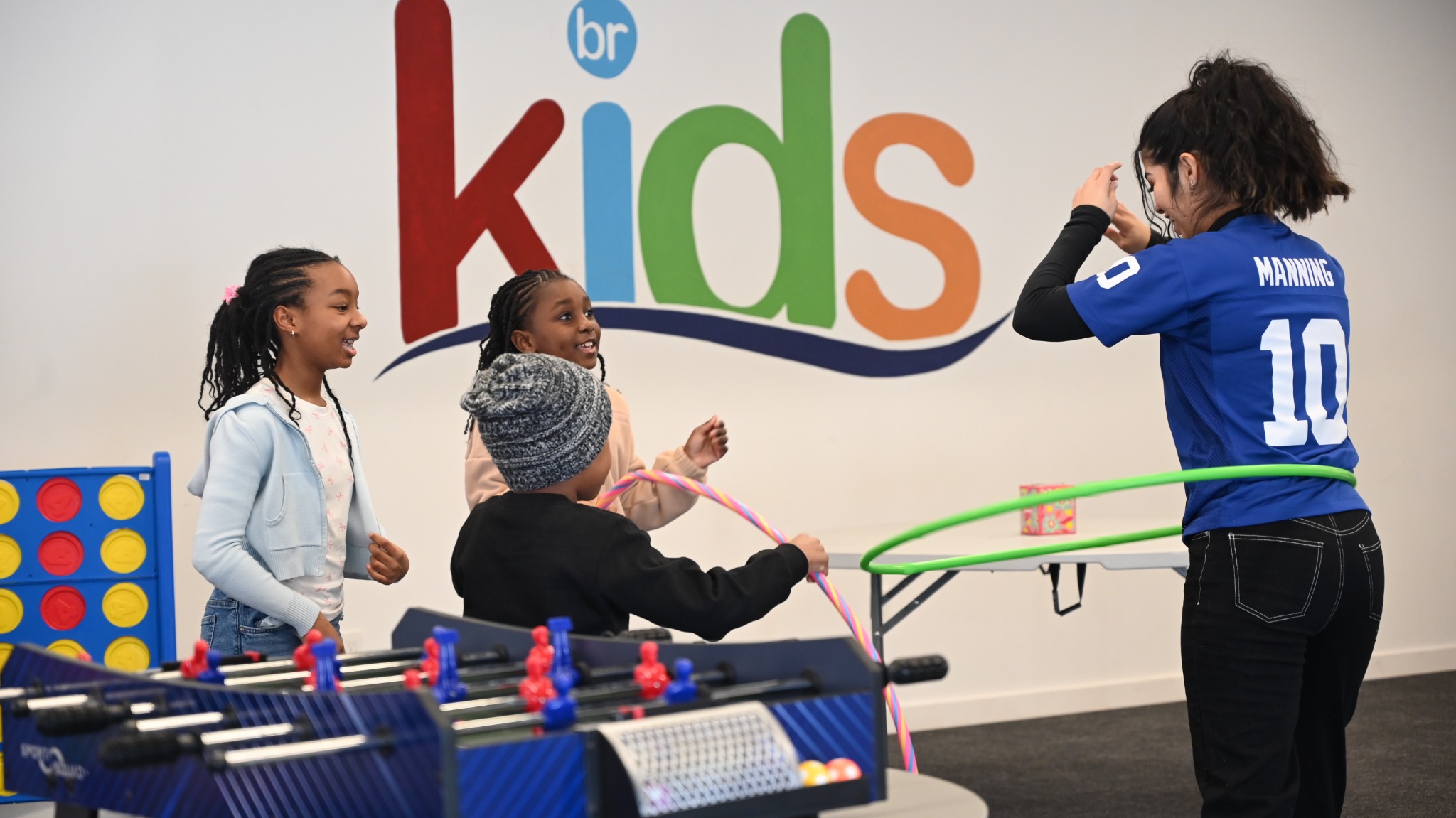 Children enjoying hula hoops together in the BRDRVR KIDS room