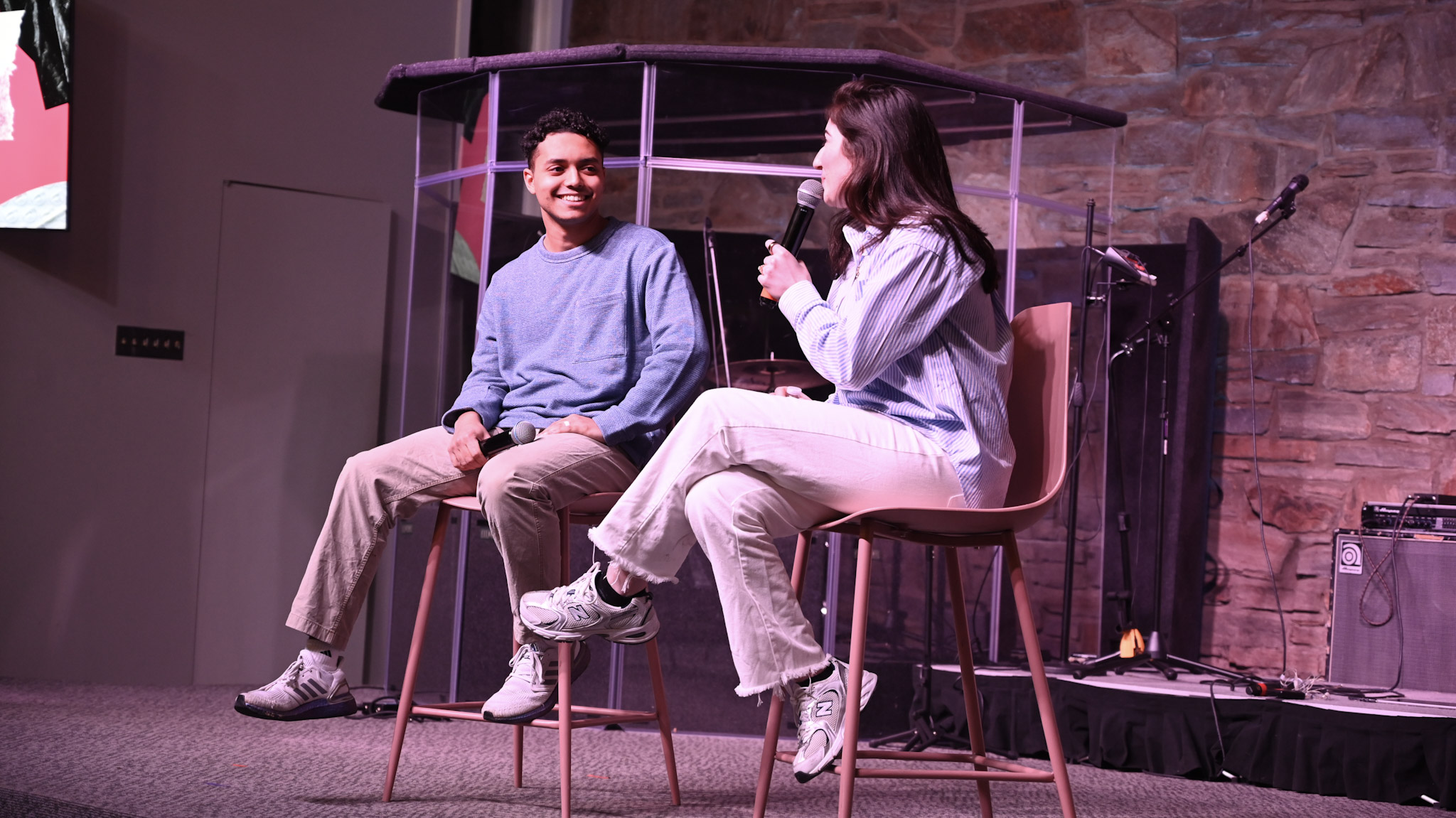 Two people sharing a conversation with microphones on stage