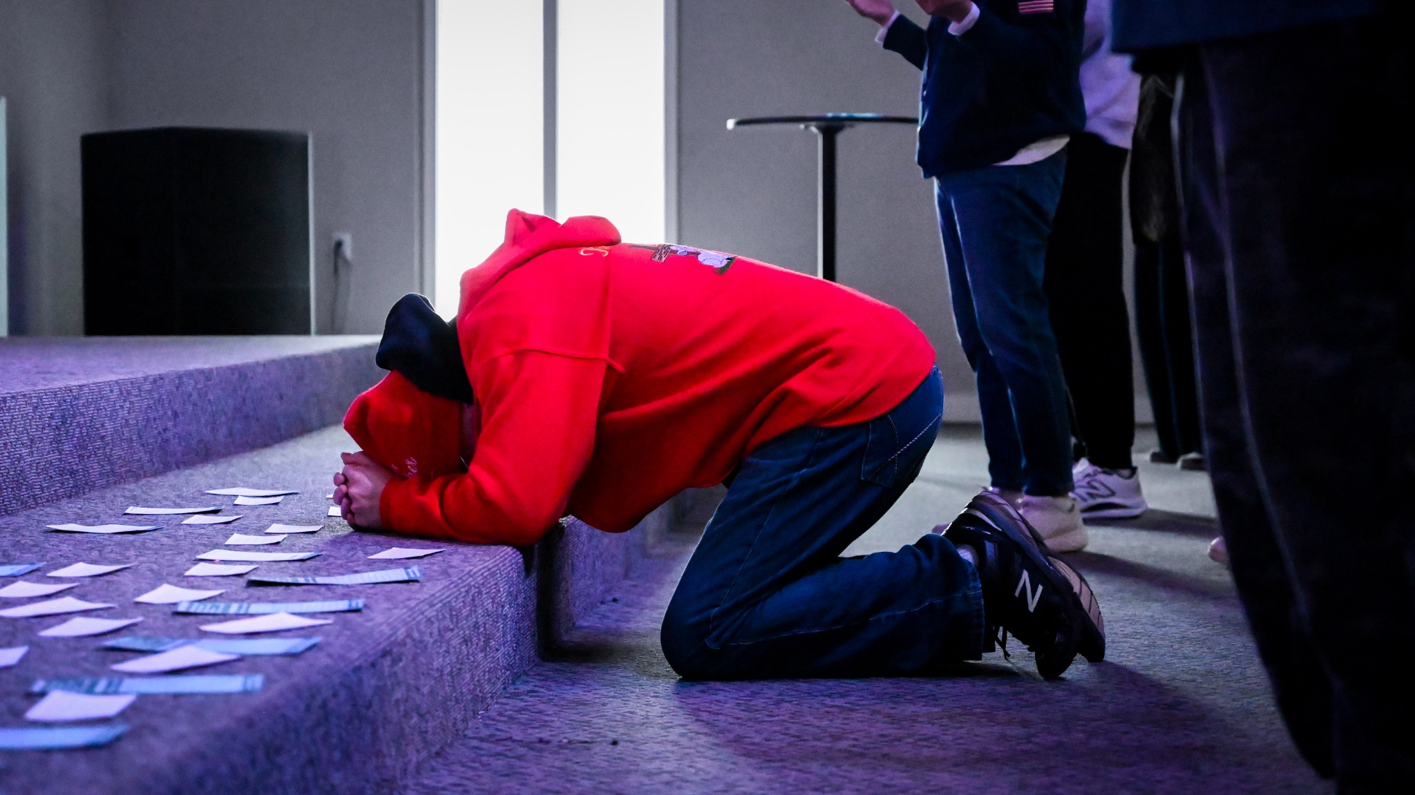 A person kneeling in prayer at Broad River Church