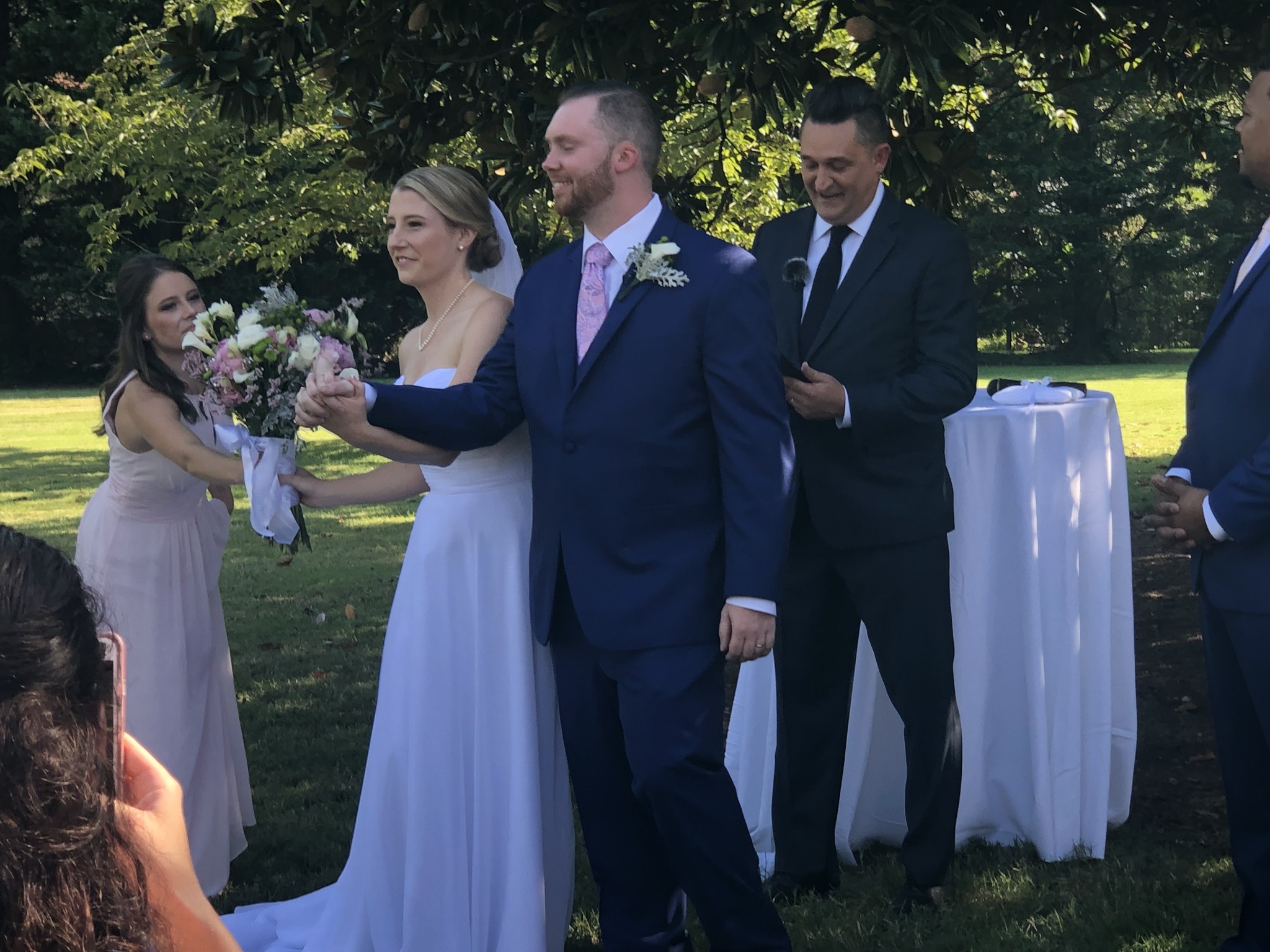 Kevin sharing a joyful moment with a couple at an outdoor wedding