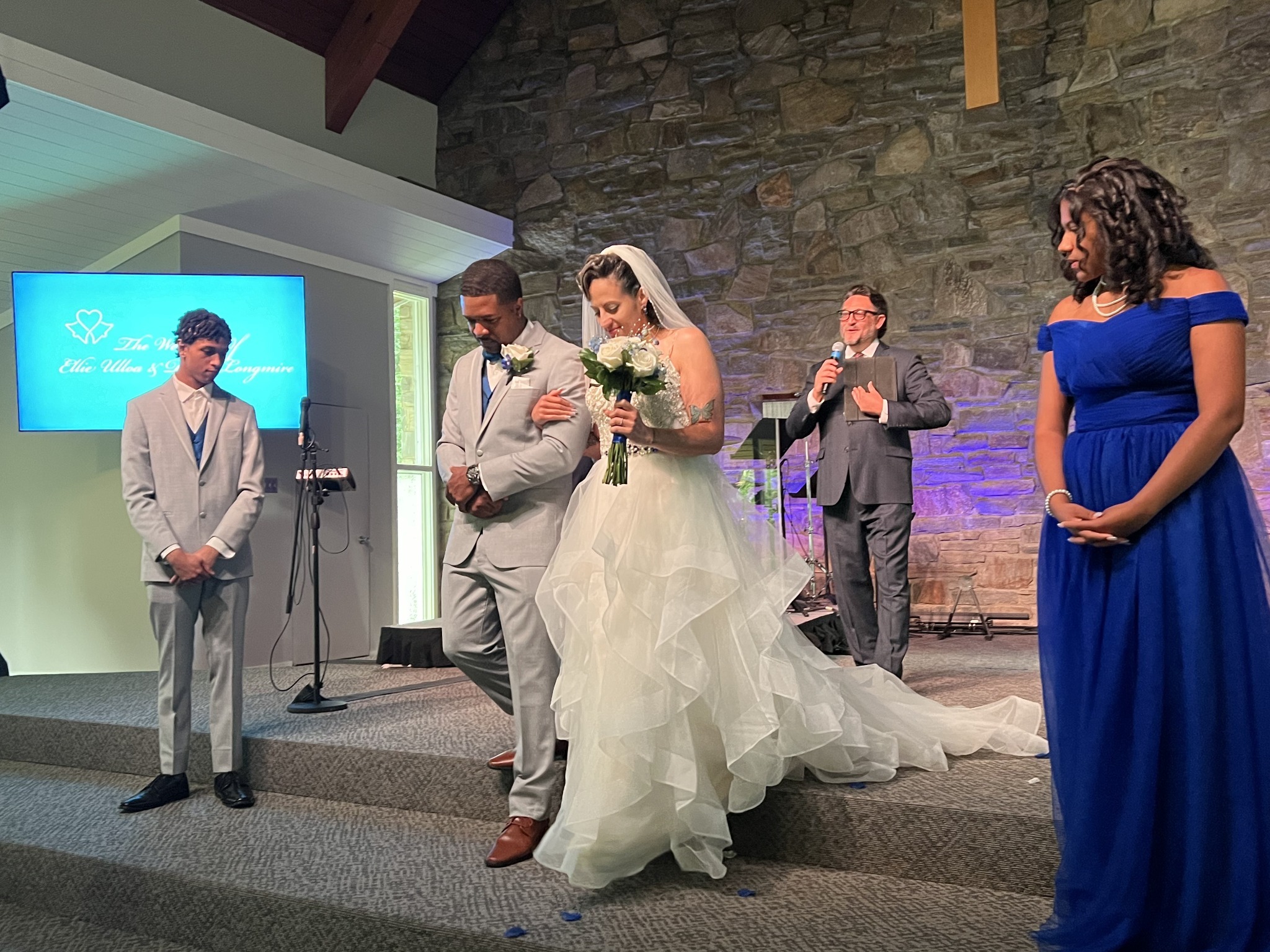 Kevin leading a prayer with a bride, groom and wedding party in Broad River Church