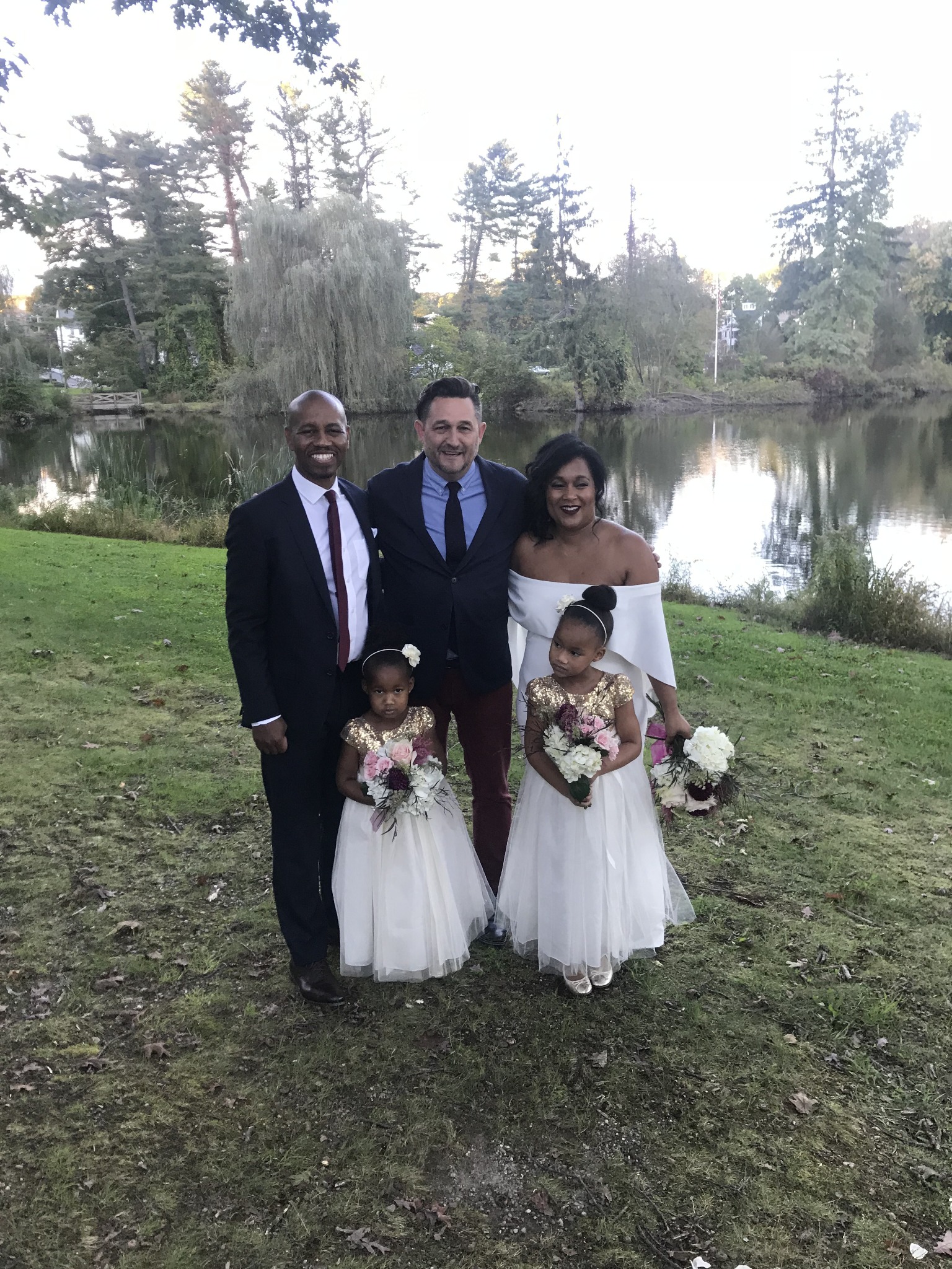Kevin with a newly married couple and two children beside a lake