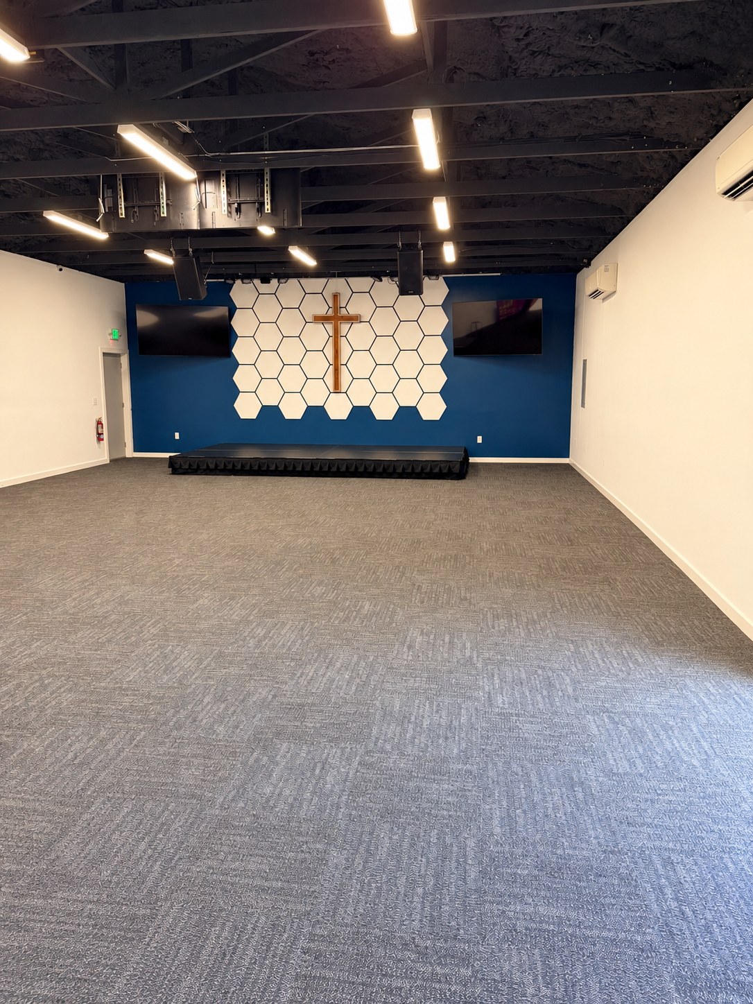 Gathering House interior showing the open floor, stage, cross and ceiling lights